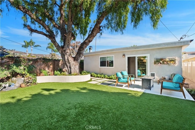 rear view of house with a patio area, outdoor lounge area, and a yard