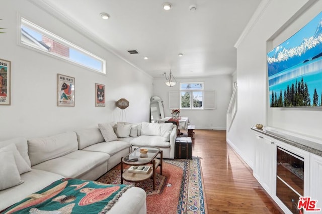 living room featuring crown molding, a healthy amount of sunlight, and wood-type flooring