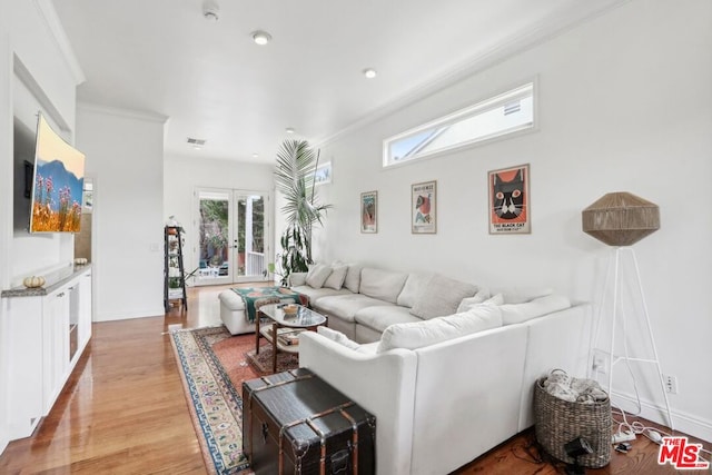 living room featuring light hardwood / wood-style flooring, french doors, and ornamental molding