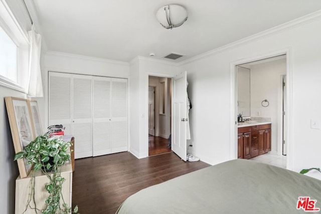 bedroom featuring hardwood / wood-style flooring, ornamental molding, sink, and connected bathroom