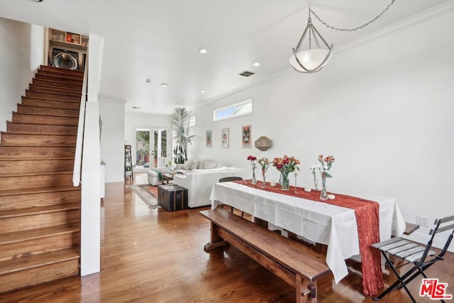 dining area with hardwood / wood-style flooring and ornamental molding