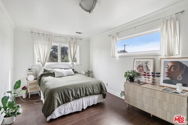 bedroom with crown molding and dark wood-type flooring