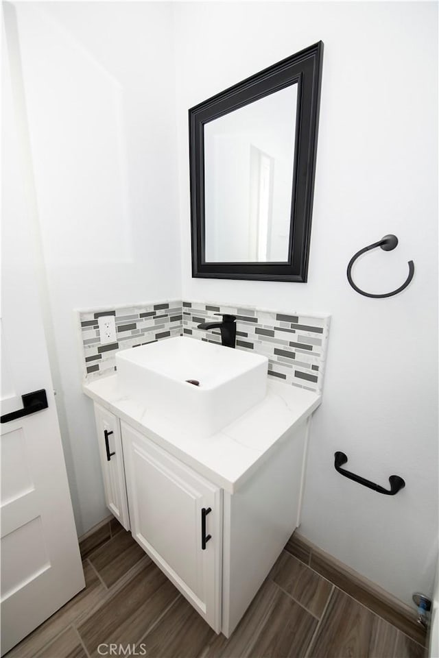 bathroom featuring backsplash, hardwood / wood-style floors, and vanity