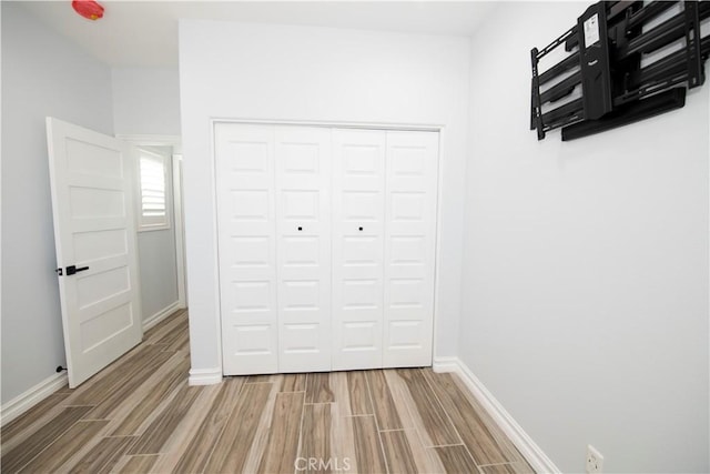 unfurnished bedroom with wood-type flooring and a closet