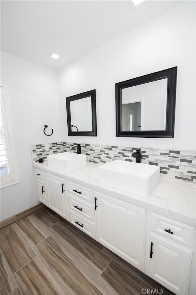 bathroom featuring decorative backsplash, vanity, and wood-type flooring