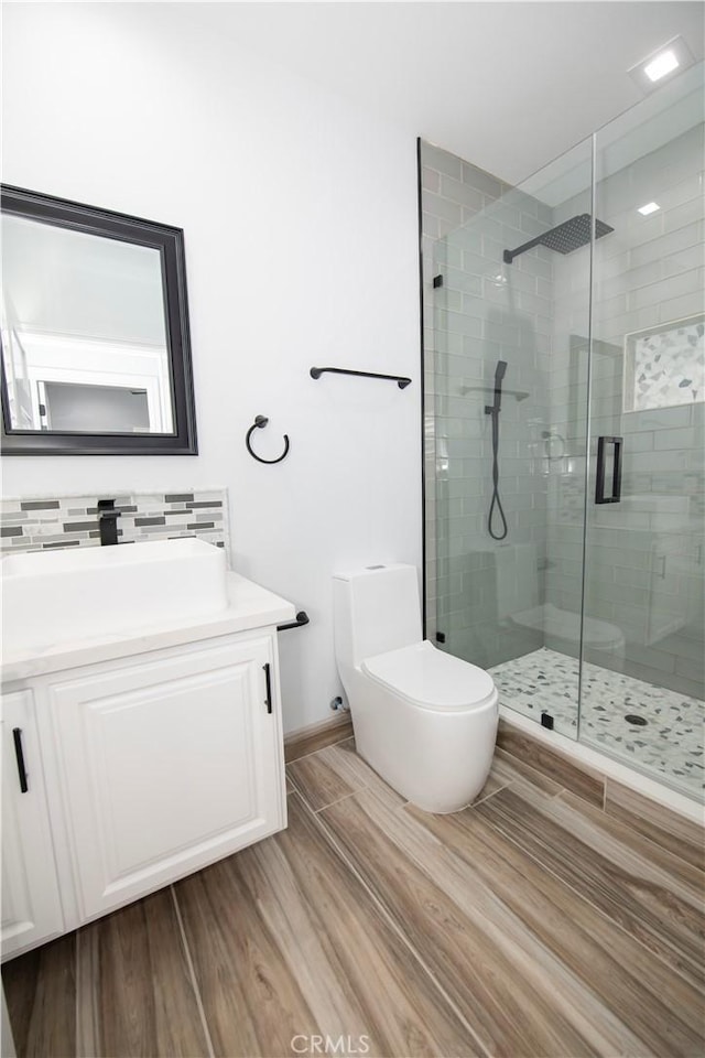 bathroom featuring toilet, hardwood / wood-style floors, vanity, and walk in shower