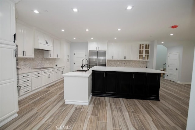 kitchen with white cabinets, appliances with stainless steel finishes, and a kitchen island with sink