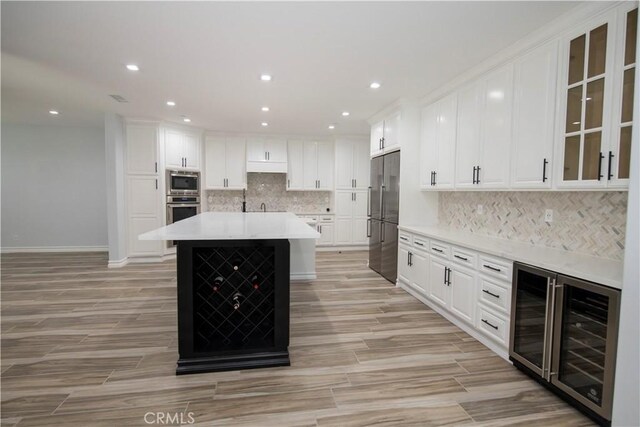 27404 Outrigger Ln, Helendale, CA 92342 - kitchen with appliances with stainless steel finishes, wine cooler, white cabinetry, light countertops, and recessed lighting