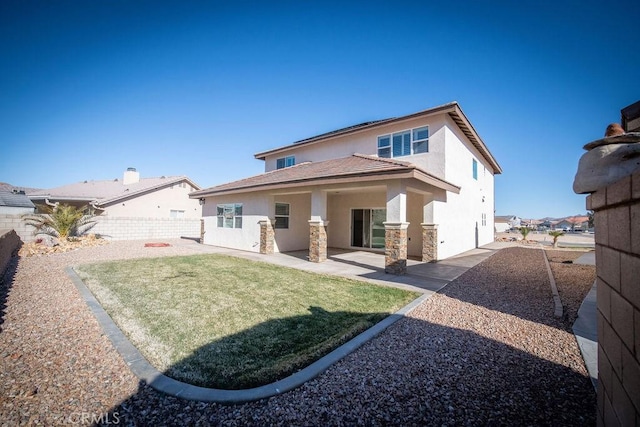 back of house with a lawn and a patio area