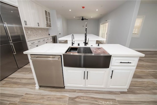 kitchen featuring sink, ceiling fan, an island with sink, white cabinetry, and stainless steel appliances