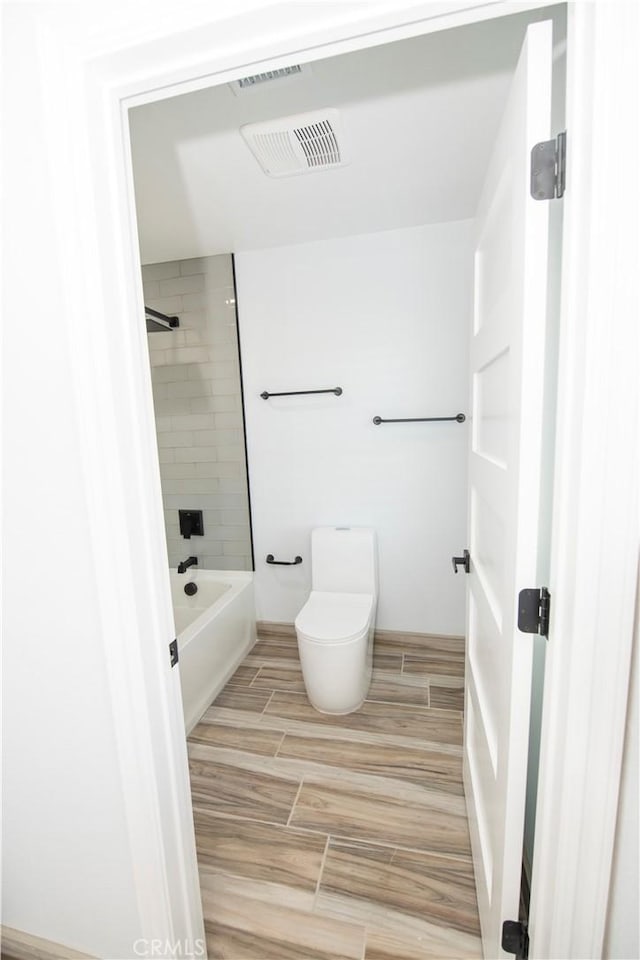 bathroom with tiled shower / bath and toilet