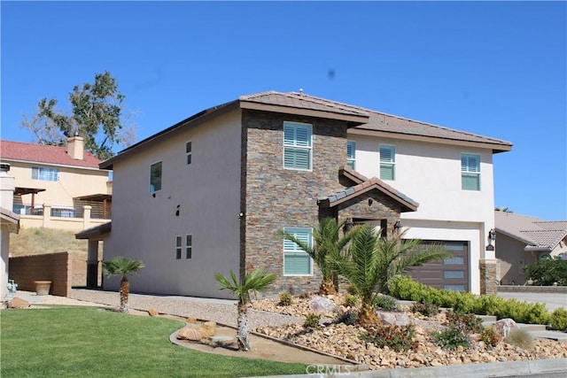 27404 Outrigger Ln, Helendale, CA 92342 - view of front of home featuring stone siding, stucco siding, and an attached garage