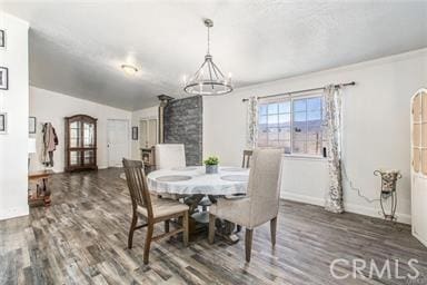 dining room featuring lofted ceiling, dark wood-type flooring, and a notable chandelier