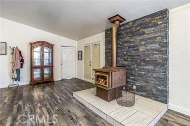 unfurnished living room featuring a wood stove and dark hardwood / wood-style flooring