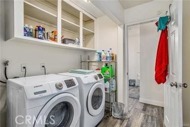 washroom featuring washing machine and dryer and wood-type flooring