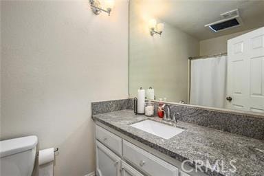 bathroom featuring vanity and toilet