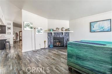 living room featuring a fireplace, hardwood / wood-style flooring, crown molding, and lofted ceiling