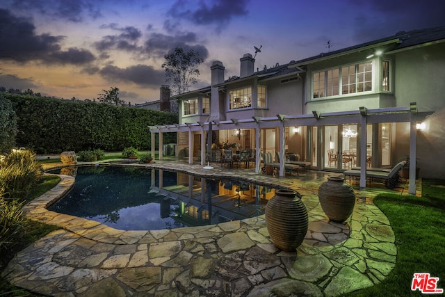 pool at dusk featuring a pergola and a patio area