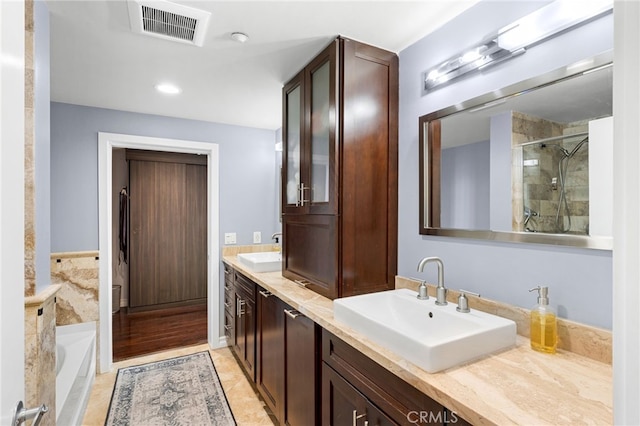 bathroom featuring vanity, independent shower and bath, and tile patterned flooring