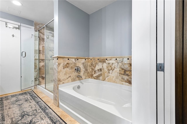 bathroom featuring shower with separate bathtub and tile walls