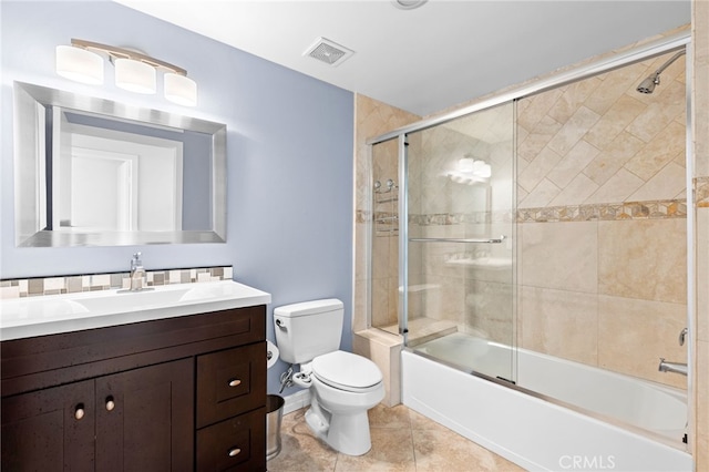 full bathroom featuring vanity, shower / bath combination with glass door, toilet, and tile patterned floors