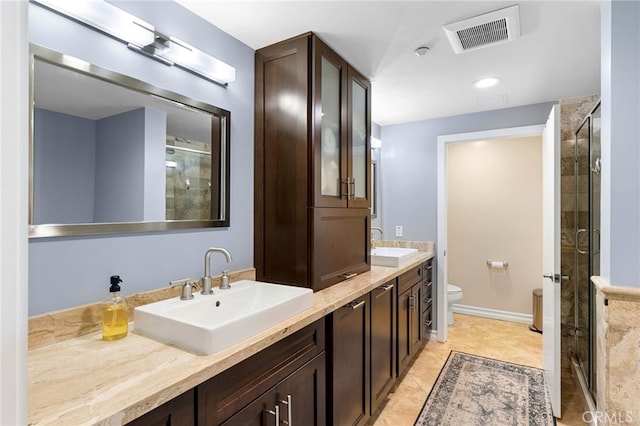 bathroom with toilet, a shower with shower door, vanity, and tile patterned flooring