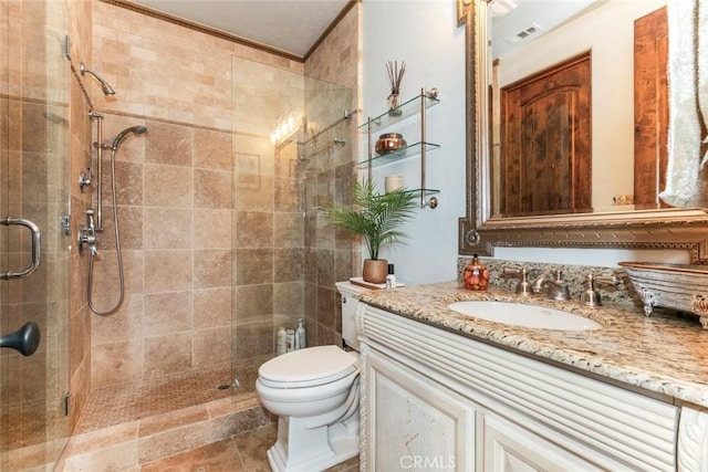 bathroom with a shower with door, vanity, and toilet