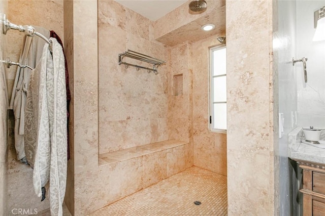 bathroom featuring vanity and tiled shower