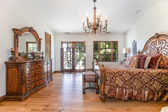 bedroom featuring access to exterior, a chandelier, and light hardwood / wood-style floors