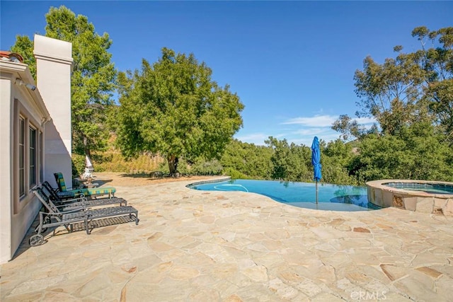 view of swimming pool featuring an in ground hot tub and a patio