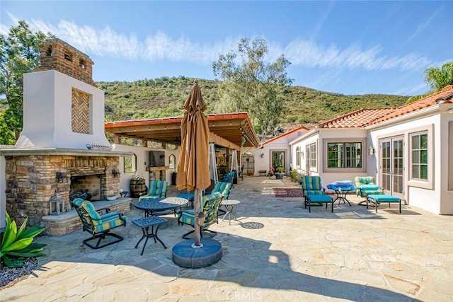 view of patio / terrace featuring an outdoor living space with a fireplace and a mountain view