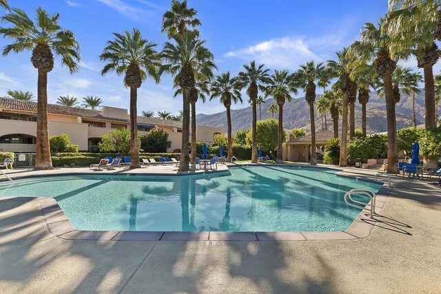 view of pool featuring a mountain view and a patio