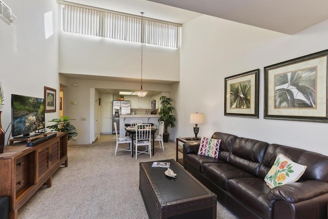 carpeted living room featuring a high ceiling