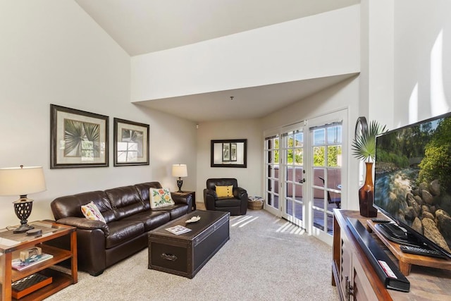 living room featuring lofted ceiling, light colored carpet, and french doors