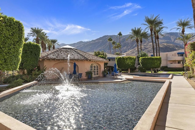 exterior space featuring a mountain view and pool water feature