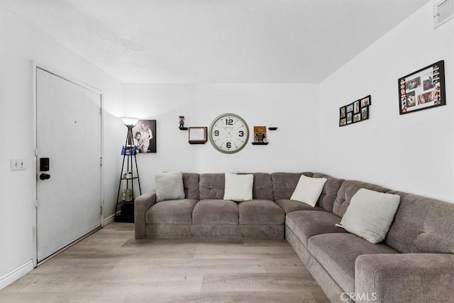 living area with light wood-type flooring and visible vents