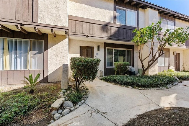 property entrance featuring a tiled roof and stucco siding