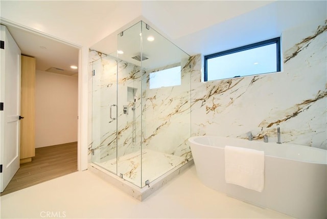 full bath featuring recessed lighting, wood finished floors, a marble finish shower, and a soaking tub