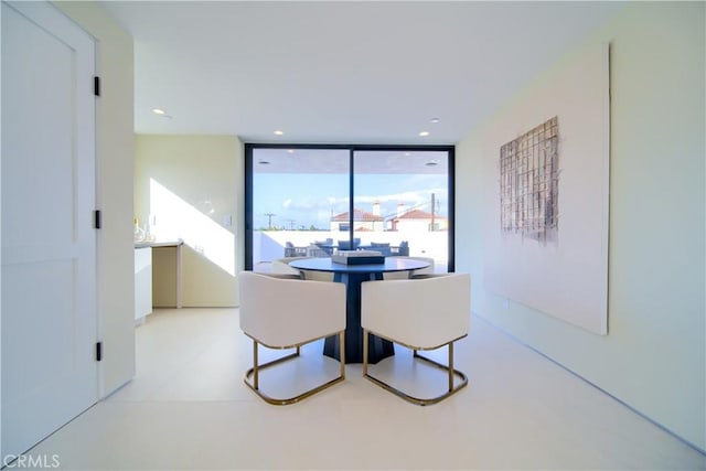 dining space with floor to ceiling windows and recessed lighting