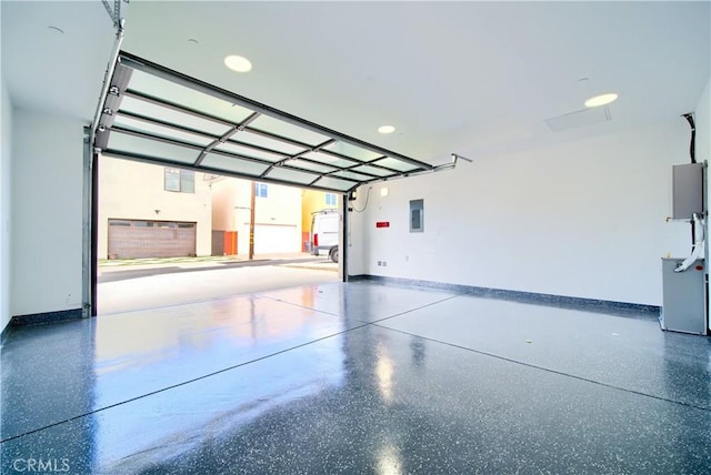 garage featuring baseboards and electric panel