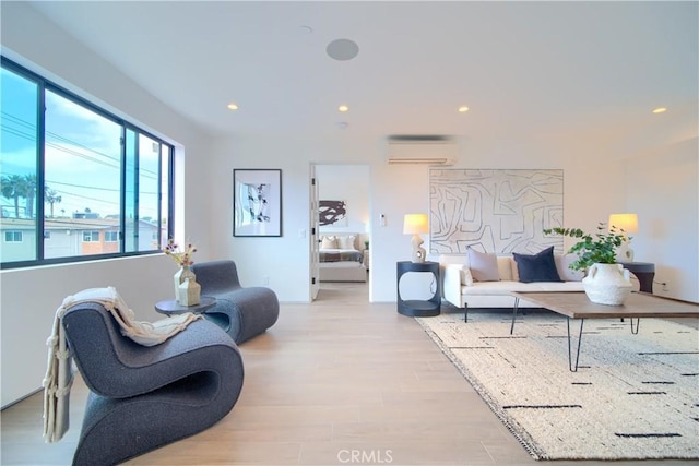 living area with light wood-style flooring, recessed lighting, and a wall mounted air conditioner