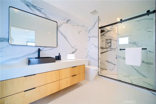 full bathroom featuring toilet, stone wall, a marble finish shower, and vanity