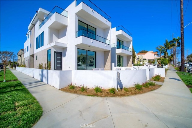 view of property exterior with a fenced front yard, a residential view, and stucco siding