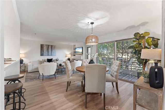 dining area with light hardwood / wood-style flooring and a textured ceiling