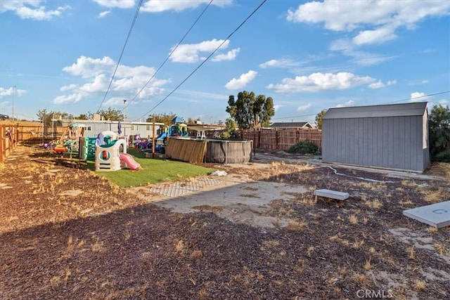 view of yard with a playground and a storage shed