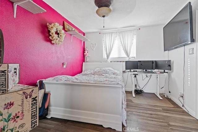 bedroom featuring ceiling fan and dark wood-type flooring