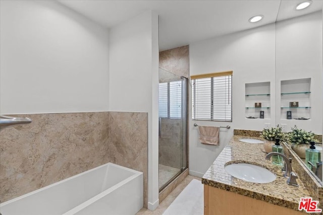 bathroom with vanity, separate shower and tub, and tile walls