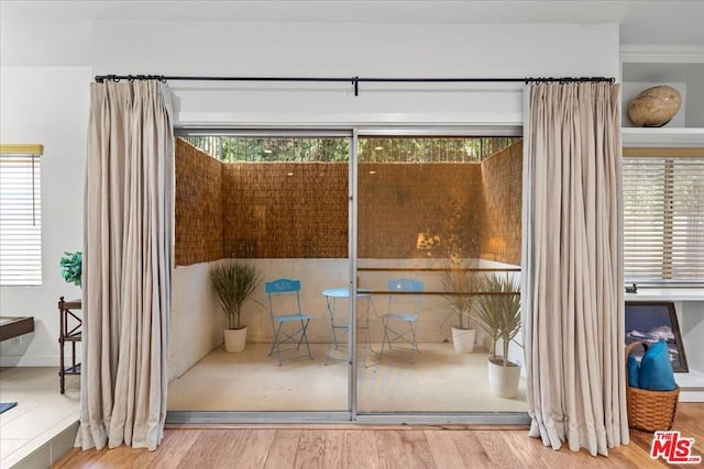 doorway with hardwood / wood-style floors and a wealth of natural light