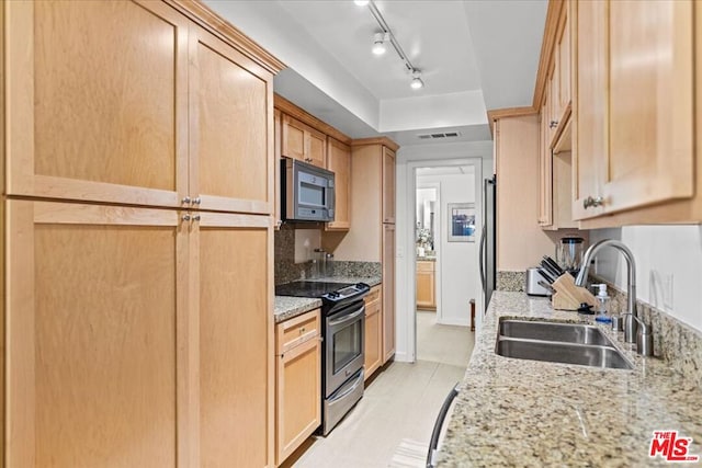 kitchen featuring light brown cabinets, sink, light tile patterned floors, light stone countertops, and appliances with stainless steel finishes