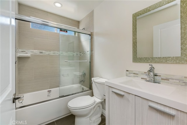 full bathroom with toilet, combined bath / shower with glass door, vanity, and backsplash